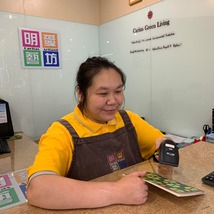 會員在綠色生活空間的店舖內，專注地操作收銀機，進行結賬。