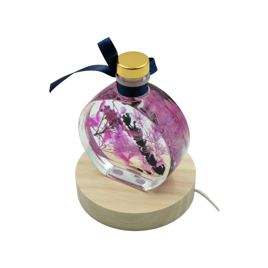 圓扁玻璃瓶內飄蕩著粉紫色永生花,柔美浪漫。