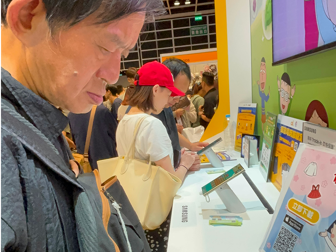 Members participated in electronic mini-game activities in the venue, concentrating on the game screen.